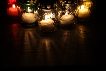 Many grave candles on black background, closeup