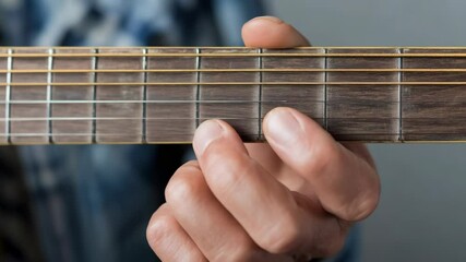 Hand playing acoustic guitar fretboard - Powered by Adobe