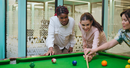 Indian happy young adult gen z woman lady hold cue stick hit ball play sport game on pool table...