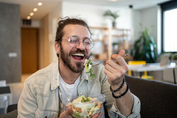 Joyful man enjoying a healthy salad at home