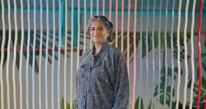 Indian Asian gen x old gray haired senior boss ceo woman smiling look camera do pose at work place happy older elder mature adult lady staff worker proud staring cam indoor job office enjoy day	