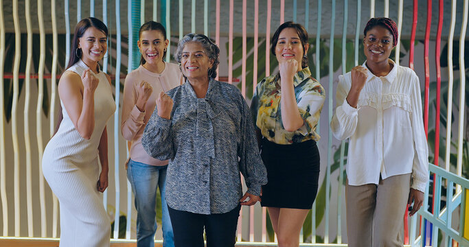 Indian happy old aged elder women senior boss lady team leader look camera indoor work place Asian young adult proud female girl expert staff group staring cam do pose raised hand fist job office