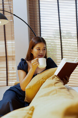 Woman enjoys book and music in modern abode.