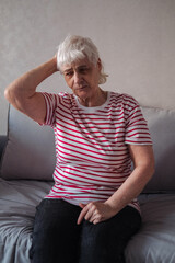 Worried senior woman at home felling very bad