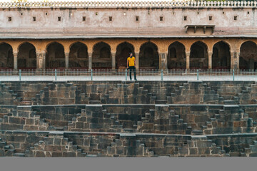Chand Baori, an Ancient 13-Storey Stepwell in Abhaneri, Rajasthan. Male Tourist Exploring One of the Largest and Oldest Stepwells in India