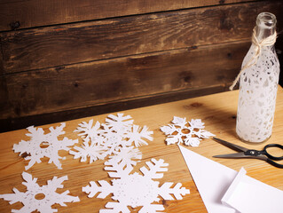 Winter Craft Table with Snowflake Cutouts and White Bottle 