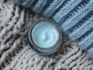 Winter Skincare Flatlay: Light Blue Moisturizer Balm in Glass Jar with Knitted Fabric 