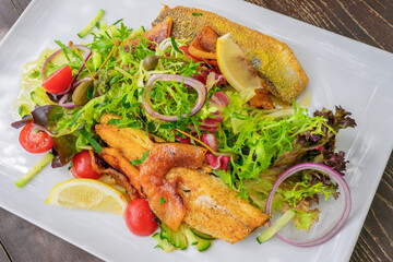 sea bass fillet with grilled melons and salad close up