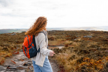 Hiking on a scenic trail with a backpack in the countryside while admiring the distant landscape...