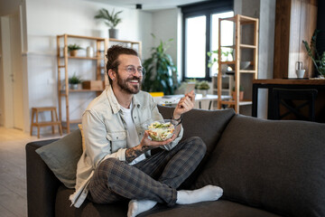 Freelancer enjoying healthy lunch break on sofa at home