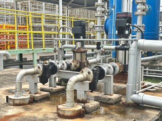 pipes and valves. Large industrial pumps and insulated piping system in a modern chiller plant. Key components for thermal energy transfer and HVAC operations in commercial or industrial facilities.
