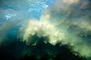 Underwater view of the whitewater textures created by an ocean wave exploding onto a shallow reef.