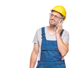 Friendly middle-aged construction worker on the phone, isolated on white background. Happy repairman using the smart phone, copy space for text. Craftsman against white wall
