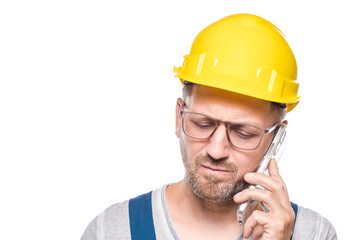 Closeup worried middle-aged construction worker with the mobile phone, isolated on white background. Bad news. Craftsman against white wall