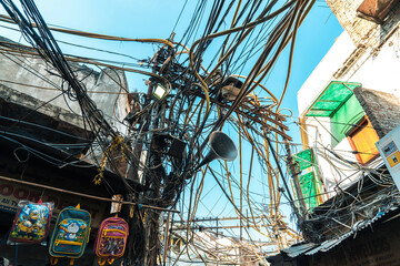 Old Delhi streets, India. Busy market alleys with rickshaws, historic architecture, vibrant local life, and tangled overhead cables.