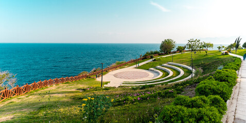 Panoramic view of a terraced amphitheater near the sea in Antalya, Turkey. Bright blue sky,...