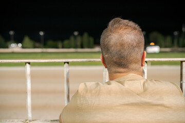 Man observing nighttime race track scene