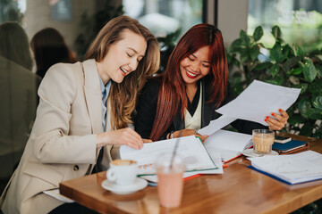 Business associates collaborating over papers while enjoying beverages in a relaxed cafe ambiance