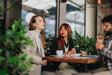 Business professionals in a casual outdoor setting collaborating on a project, showcasing teamwork...