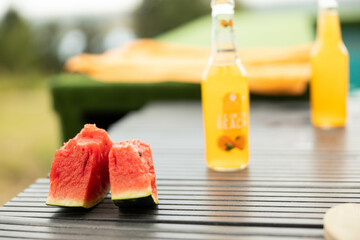 Fresh watermelon slices and colorful drinks on a table evoke summer vibes, perfect for outdoor...