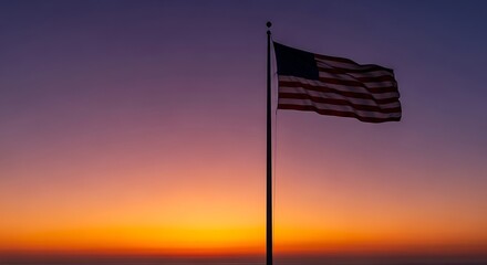 American flag waving proudly at sunset, silhouetted against vibrant colors.
