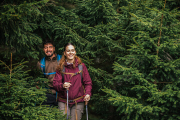 Young Couple Hiking Through Rough Mountain Path and Bushes with Full Gear