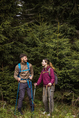 Young Couple Hiking Through Rough Mountain Path and Bushes with Full Gear
