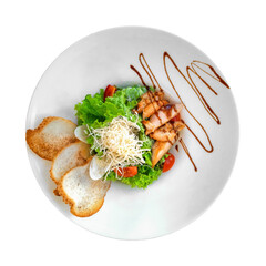 caesar salad with chicken and croutons on plate isolated on white background with clipping path