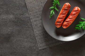 grilled sausages on dark plate, top view