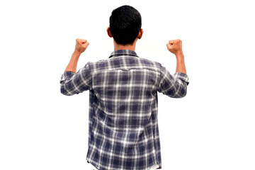 Rear view of a celebrating Asian man in a plaid shirt with fists raised in success on a white...