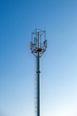 mobile phone and wireless connection tower on the background of the sky