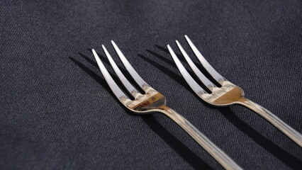 two forks on black tablecloth