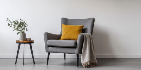 Fototapeta premium Interior of living room. Gray armchair, green pillow, coffee table and beige wall. Velour Chair against light wall, wooden floor, parquet. Home improvement. Beautiful luxurious modern room settings.