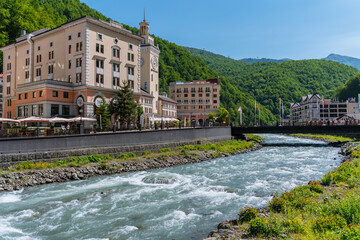 Rosa Khutor resort, buildings and river at the foot of the mountains. Sochi, Russia - 8 June 2025