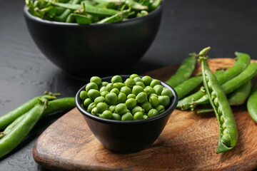Fresh ripe green peas on black table, closeup