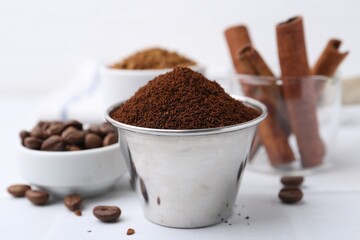 Instant coffee powder, beans and cinnamon sticks on light table, closeup