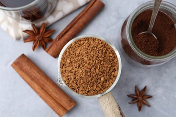 Different types of instant coffee and spices on grey table, flat lay