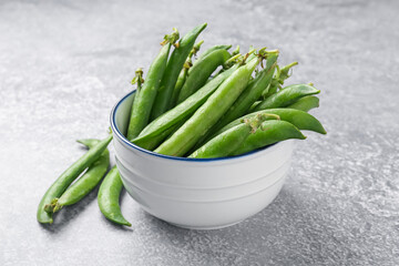 Fresh ripe green peas on grey table, closeup
