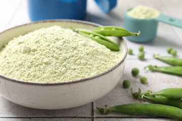 Protein powder and green peas on light tiled table, closeup