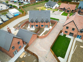Newly completed terraced affordable homes together with detached homes and bungalows in a rural Essex, UK housing development. Lawns have now started to be laid in rear gardens.