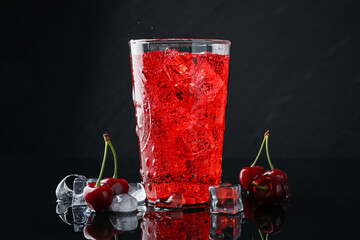 Tasty cherry soda with ice cubes, berries and mint in glass on black background, closeup