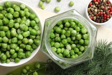 Fresh green peas, pickling jar, spices and dill on white table, flat lay