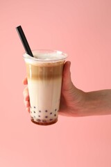 Woman with tasty milk bubble tea on pink background, closeup