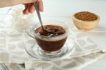 Woman making instant coffee at light table, closeup