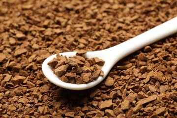 Spoon with aromatic instant coffee as background, closeup