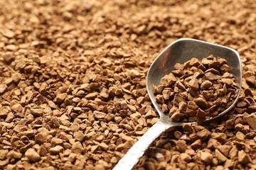 Spoon with aromatic instant coffee as background, closeup