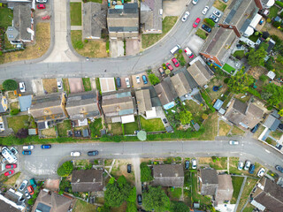 Drone view of a typical British suburban street showing both terraced and detached houses, some with large extensions and fitted solar panels to the roofs.