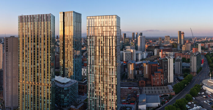 Aerial image of Manchester skyline featuring high-rise apartment buildings at Greengate during a morning sunrise. - Powered by Adobe