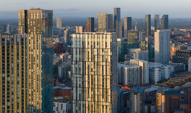Aerial image of Manchester skyline featuring high-rise apartment buildings at Greengate during a morning sunrise. 