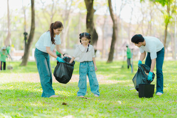 Asian family on summer vacation, parents teaching children to pick up plastic bottles and trash in...